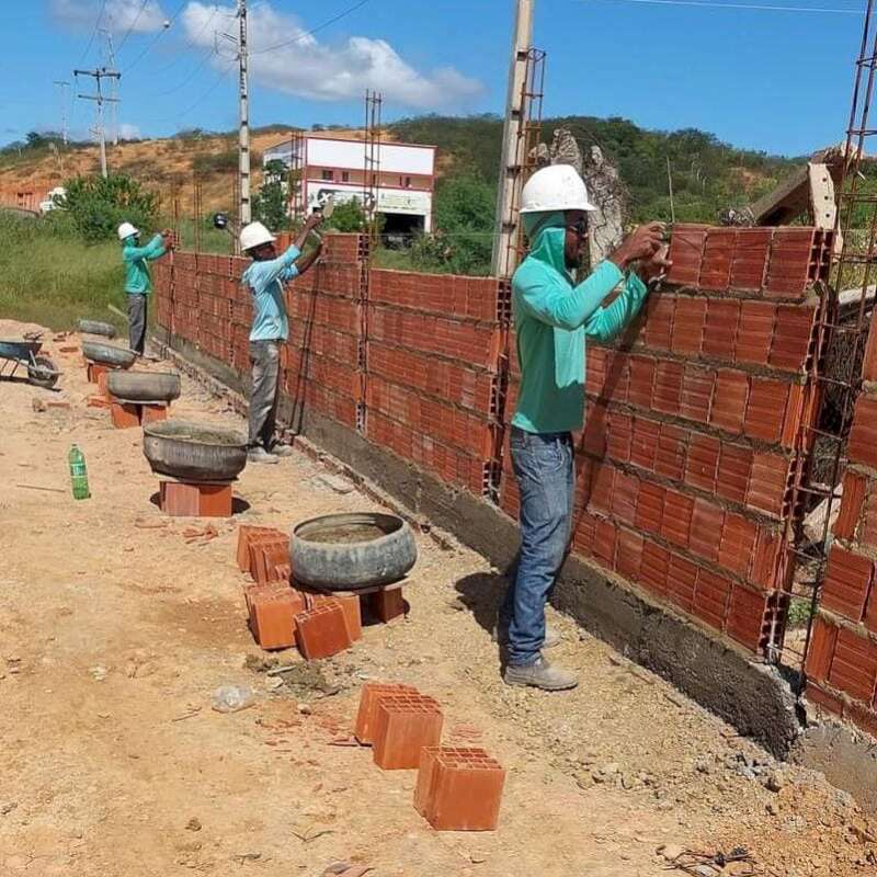 Pedreiros da empresa Construtora Supapo constroem um muro de pedra em São João do Piauí
